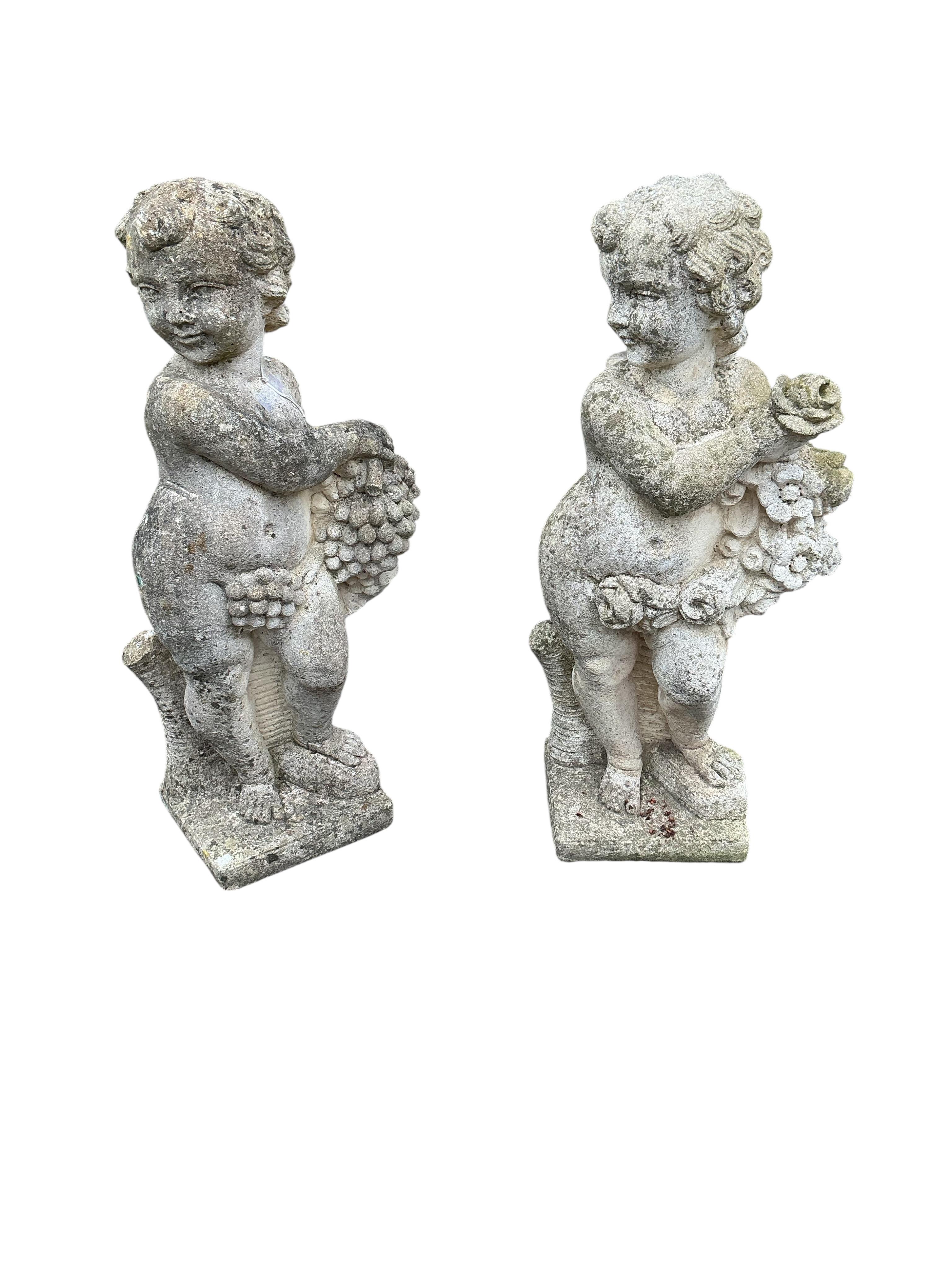 A pair of reconstituted stone cherub garden ornaments, height 80cm